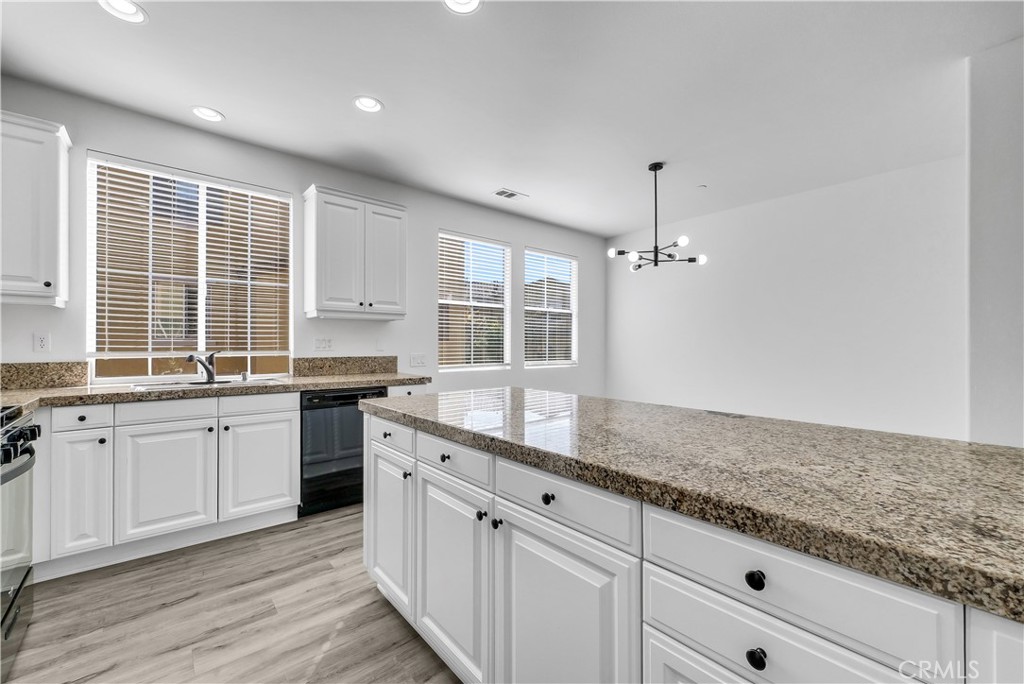 8415 Kendra Loop Orange, CA 92867 - Photo 12 of 36 a kitchen with granite countertop cabinets stainless steel appliances a sink and a window