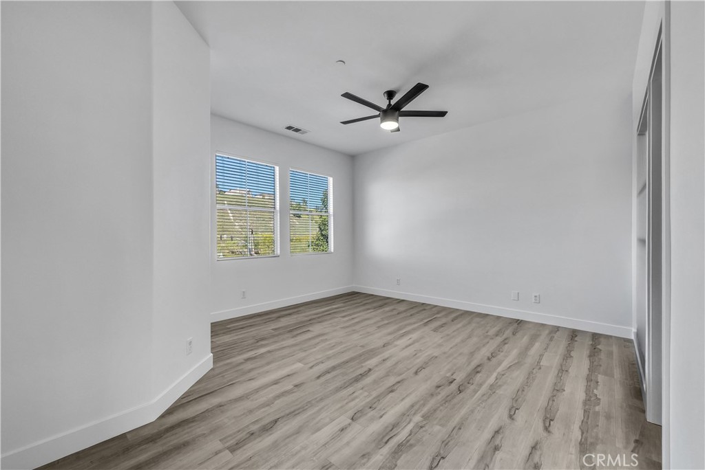 8415 Kendra Loop Orange, CA 92867 - Photo 22 of 36 an empty room with wooden floor a ceiling fan and windows