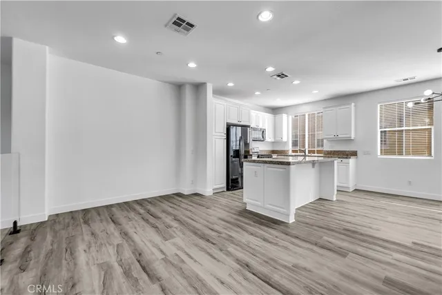 a kitchen with granite countertop cabinets stainless steel appliances a sink and a window