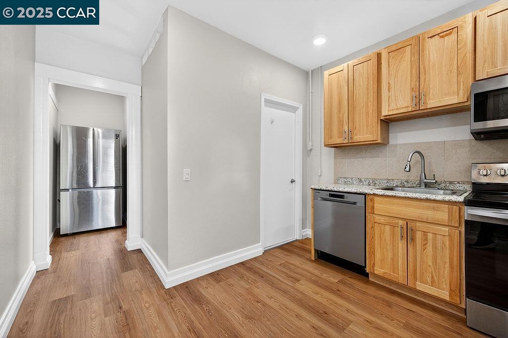 3229 Elm Street Oakland, CA 94609 - Photo 13 of 18 a kitchen with granite countertop wooden floors and wide window