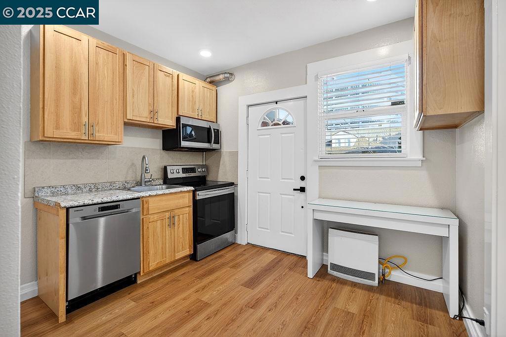 3229 Elm Street Oakland, CA 94609 - Photo 15 of 18 a kitchen with granite countertop wooden floors and stainless steel appliances