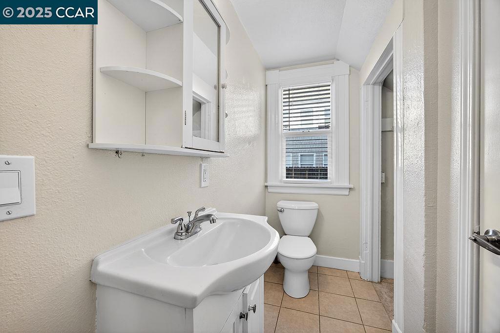 3229 Elm Street Oakland, CA 94609 - Photo 10 of 18 a bathroom with a sink a toilet and a window