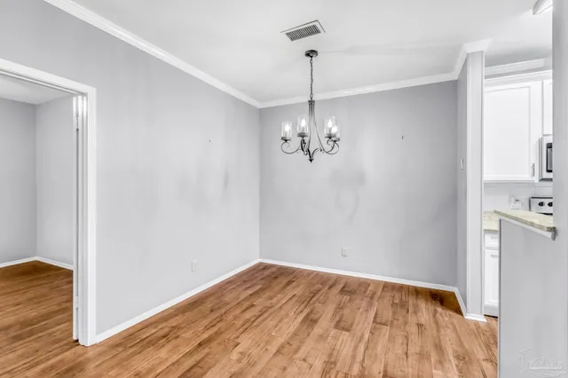 a view of empty room with wooden floor and ceiling fan