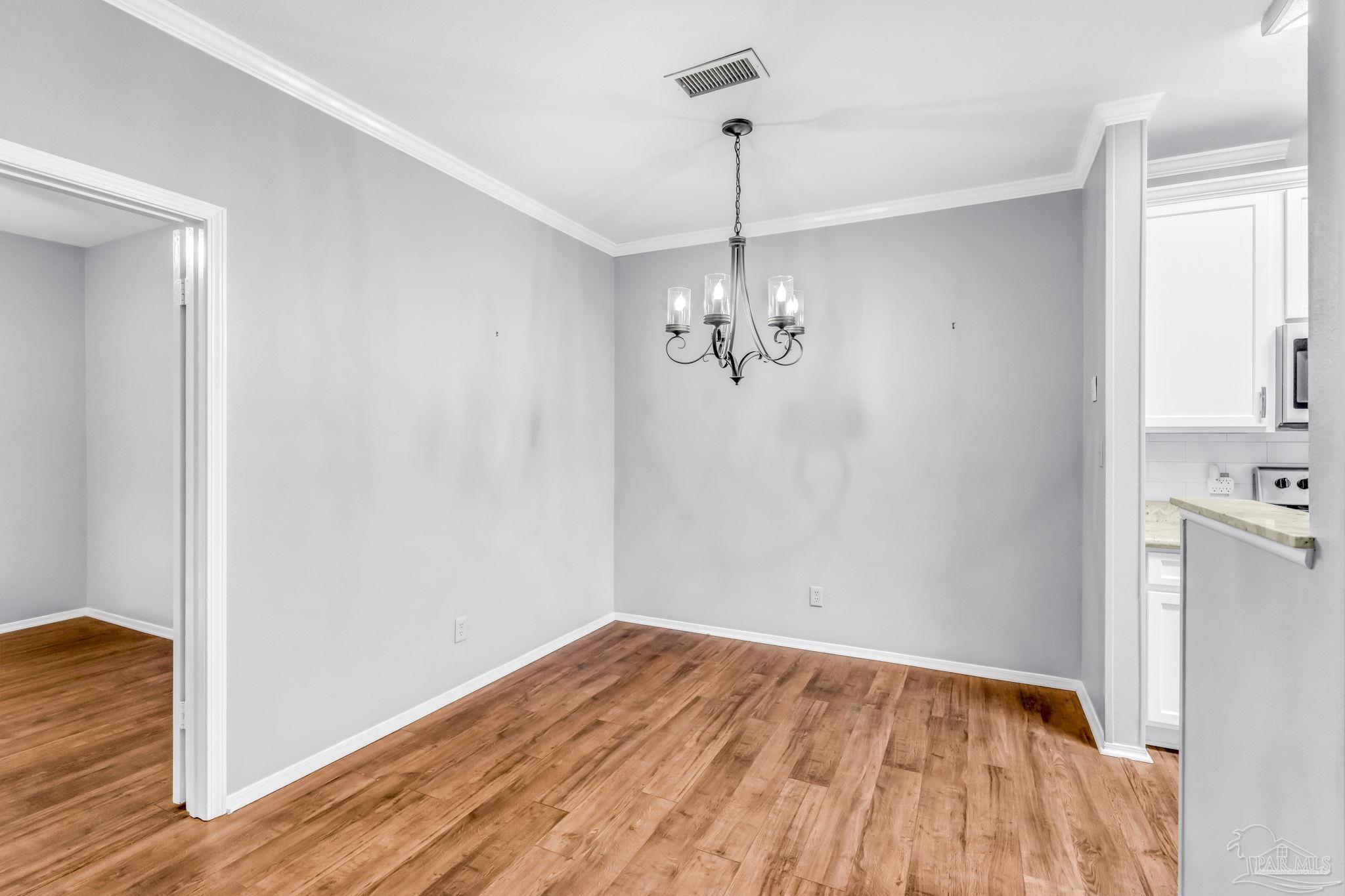 601 East Burgess Road, Unit C4 Pensacola, FL 32504 - Photo 13 of 28 a view of empty room with wooden floor and ceiling fan