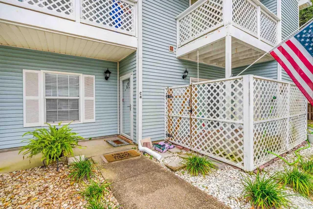 a view of a house with a small yard and wooden fence