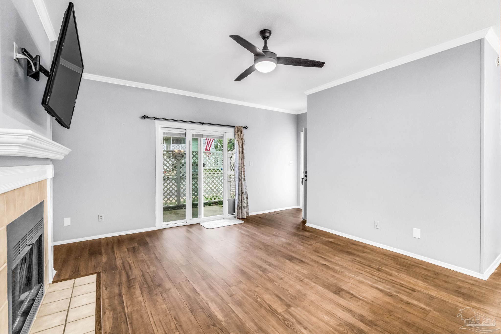 601 East Burgess Road, Unit C4 Pensacola, FL 32504 - Photo 9 of 28 an empty room with wooden floor fan and windows