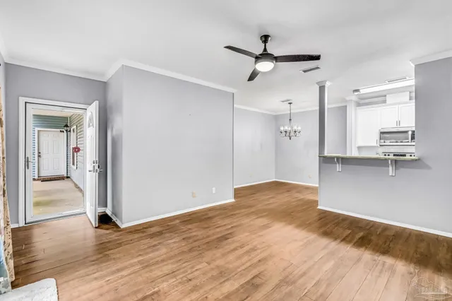 a view of empty room with wooden floor and window