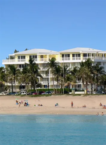 a view of a large building with a yard and plants