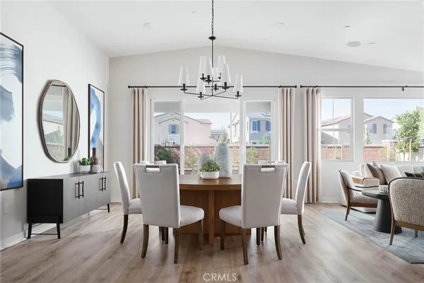 a dining room with furniture a chandelier and wooden floor