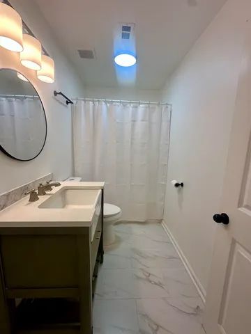 a bathroom with a sink toilet and mirror