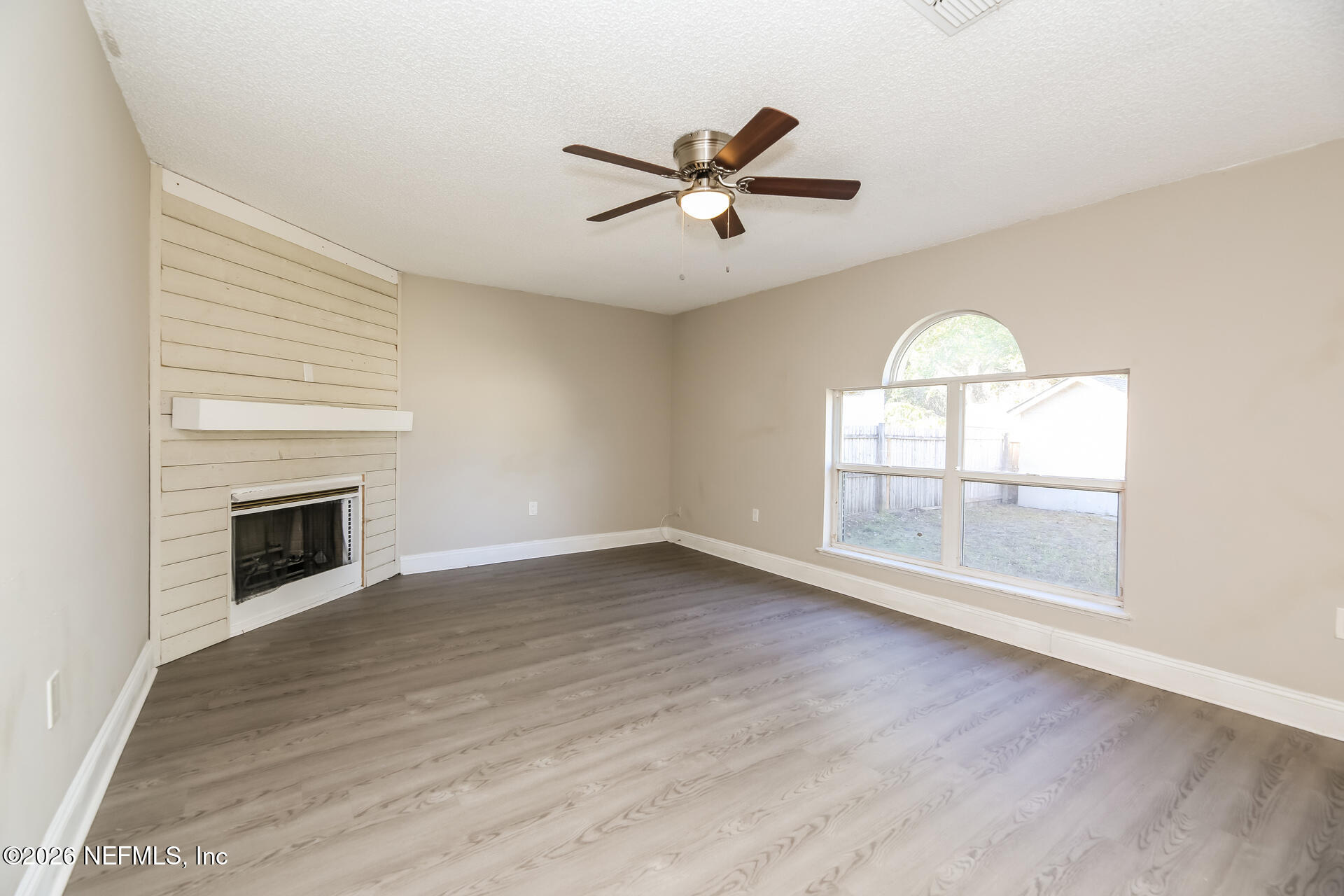 2652 Sunrise Ridge Lane Jacksonville, FL 32277 - Photo 4 of 22 an empty room with wooden floor fan and windows