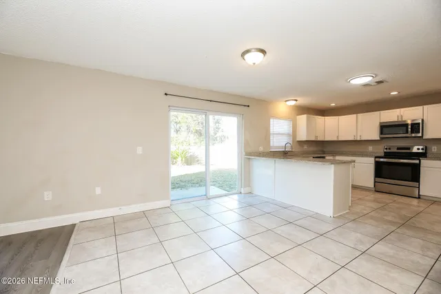 a view of kitchen with stove top oven and cabinets