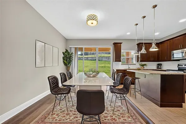 a kitchen with stainless steel appliances granite countertop a sink a refrigerator and a wooden floor