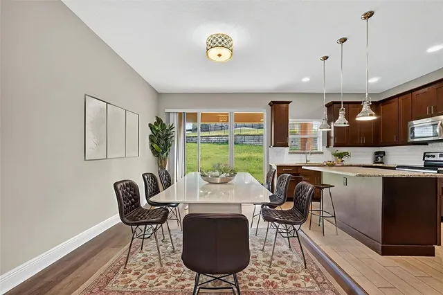 a kitchen with stainless steel appliances granite countertop a sink a refrigerator and a wooden floor