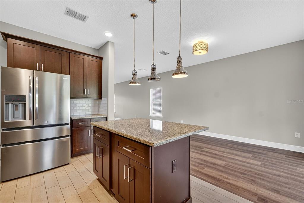 280 Wallrock Drive Ocoee, FL 34761 - Photo 21 of 88 a kitchen with stainless steel appliances granite countertop a sink a refrigerator and a wooden floor