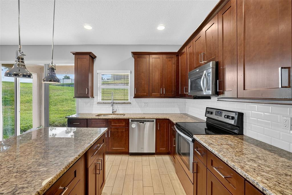 280 Wallrock Drive Ocoee, FL 34761 - Photo 24 of 88 a kitchen with stainless steel appliances granite countertop counter space a sink and cabinets