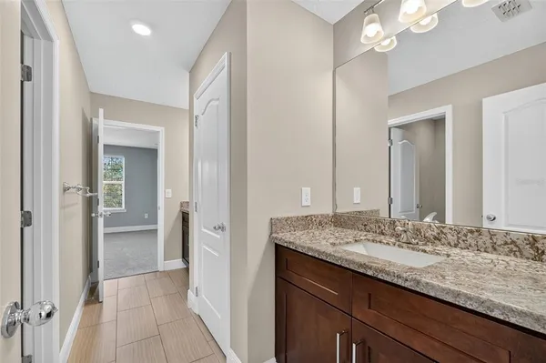 a backyard of a house with table and chairs under an umbrella