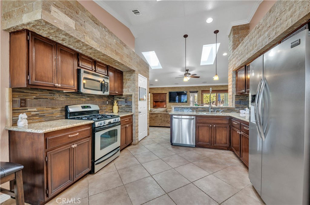 31584 Adour Way Winchester, CA 92596 - Photo 17 of 51 a kitchen with stainless steel appliances granite countertop a stove top oven a sink dishwasher and a refrigerator