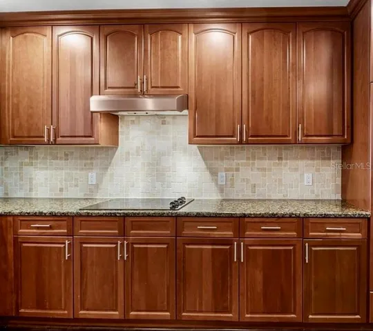 a kitchen with granite countertop wood cabinets and stainless steel appliances