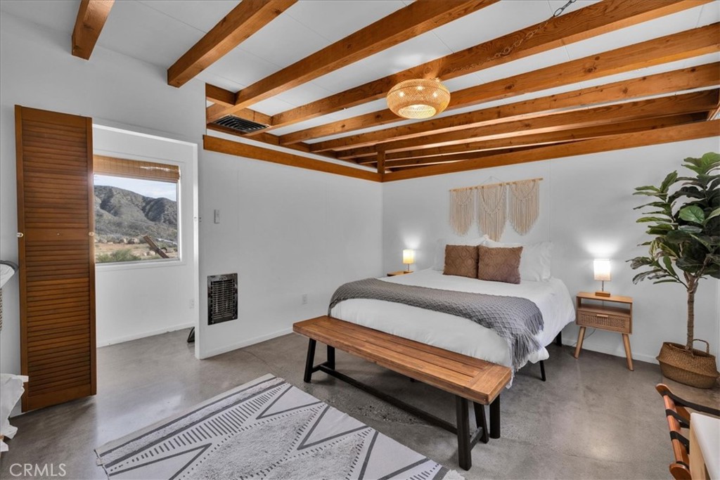 8500 South Samel Road Morongo Valley, CA 92256 - Photo 28 of 75 a bedroom with a bed and a potted plant on the dresser