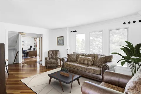 a kitchen with stainless steel appliances granite countertop a refrigerator a sink dishwasher a stove and white countertops with wooden floor