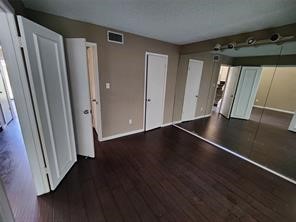 10340 Cook Road, Unit 340 Houston, TX 77099 - Photo 6 of 13 an empty room with wooden floor and staircase