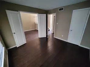an empty room with wooden floor and closet
