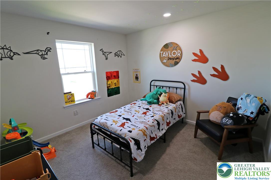 4502 Benjamin Court Emmaus, PA 18049 - Photo 36 of 53 A well-lit bedroom with carpeted floors, showcasing a window, and charming dinosaur-themed decor.