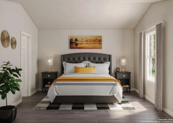 a bed sitting in a bedroom next to a window and a potted plant