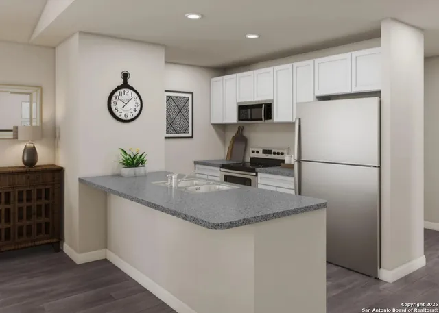 a kitchen with stainless steel appliances granite countertop a sink a stove a refrigerator a washer and dryer