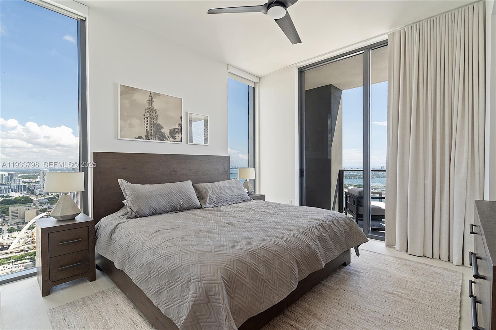 159 Northeast 6th Street, Unit 5015 Miami, FL 33132 - Photo 19 of 59 a bedroom with a bed painting on wall and a large window