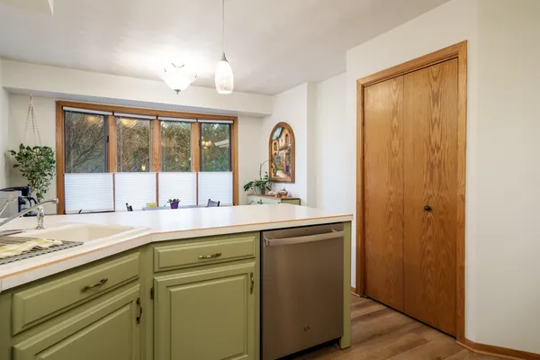 a kitchen with a refrigerator a sink and dishwasher with wooden floor