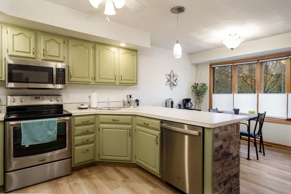 a kitchen with stainless steel appliances granite countertop a refrigerator a stove a sink and a microwave