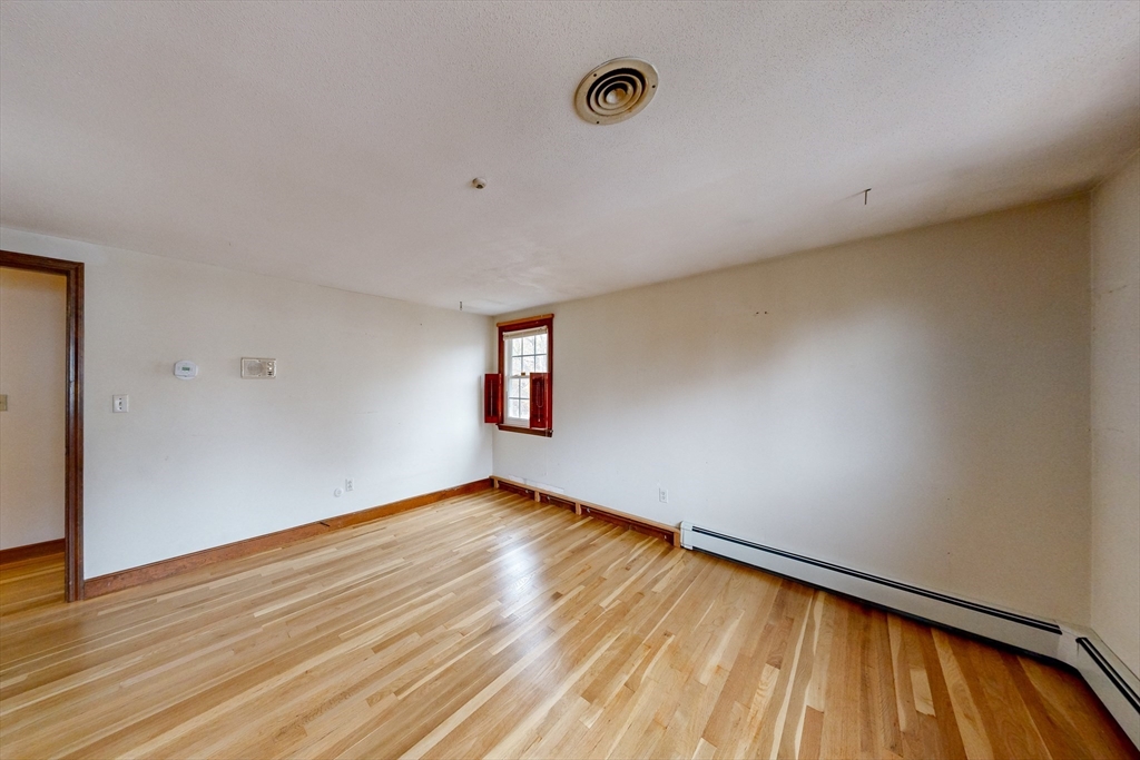 15 Rugdale Road Boston, MA 02124 - Photo 15 of 33 a view of an empty room with wooden floor and a window
