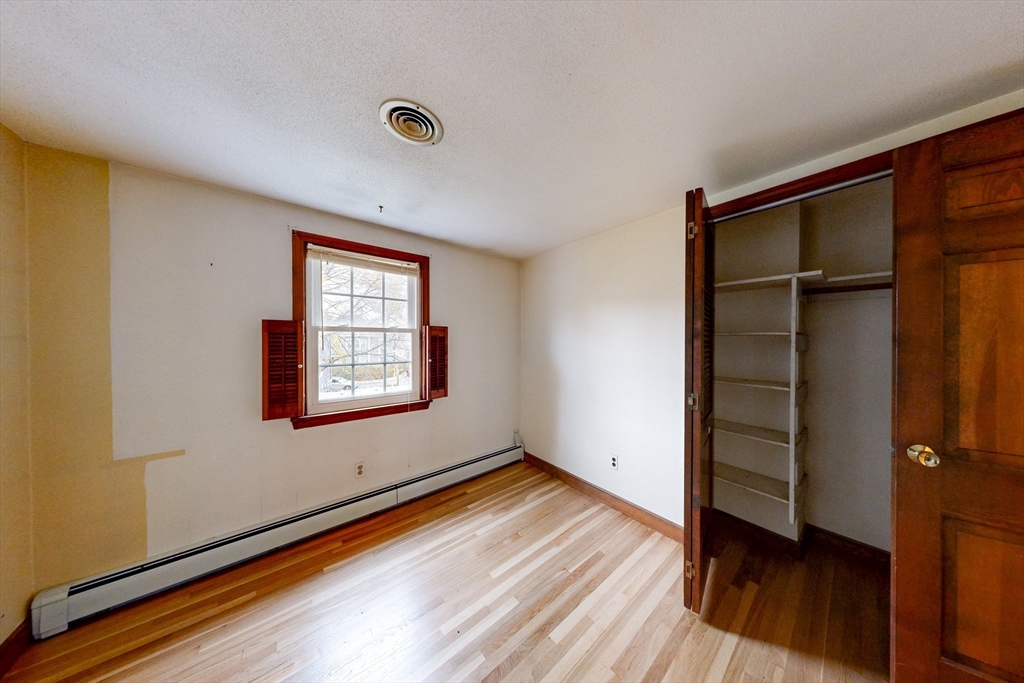 15 Rugdale Road Boston, MA 02124 - Photo 16 of 33 an empty room with wooden floor closet and windows