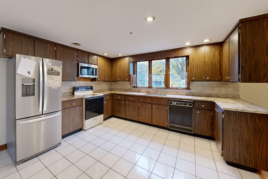 15 Rugdale Road Boston, MA 02124 - Photo 17 of 33 a kitchen with stainless steel appliances granite countertop a refrigerator sink and cabinets