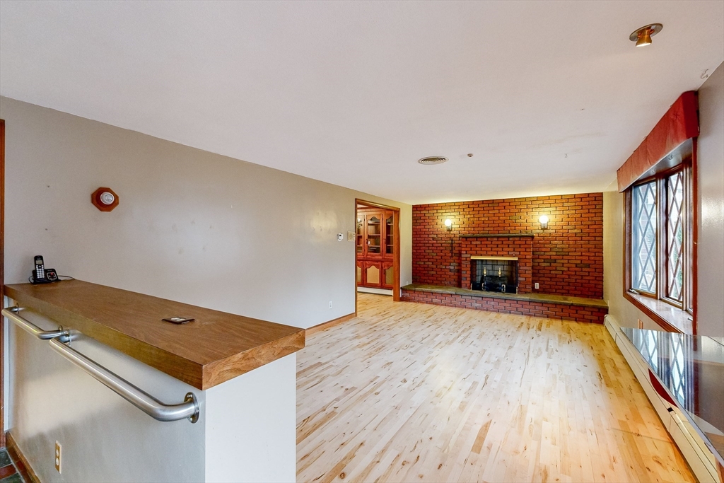15 Rugdale Road Boston, MA 02124 - Photo 6 of 33 a view of a livingroom with a fireplace and wooden floor