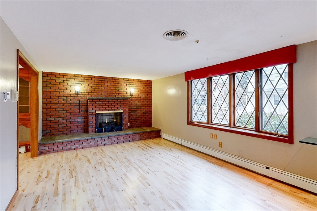 15 Rugdale Road Boston, MA 02124 - Photo 7 of 33 a view of an empty room with a fireplace and a window