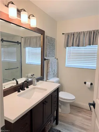 a bathroom with a sink a toilet and mirror