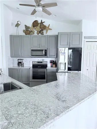 a kitchen with stainless steel appliances granite countertop a sink a stove and a refrigerator