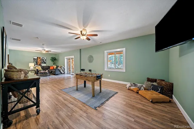 a view of a patio with table and chairs near a barbeque