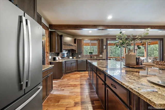 a view of a dining room with furniture a kitchen and chandelier