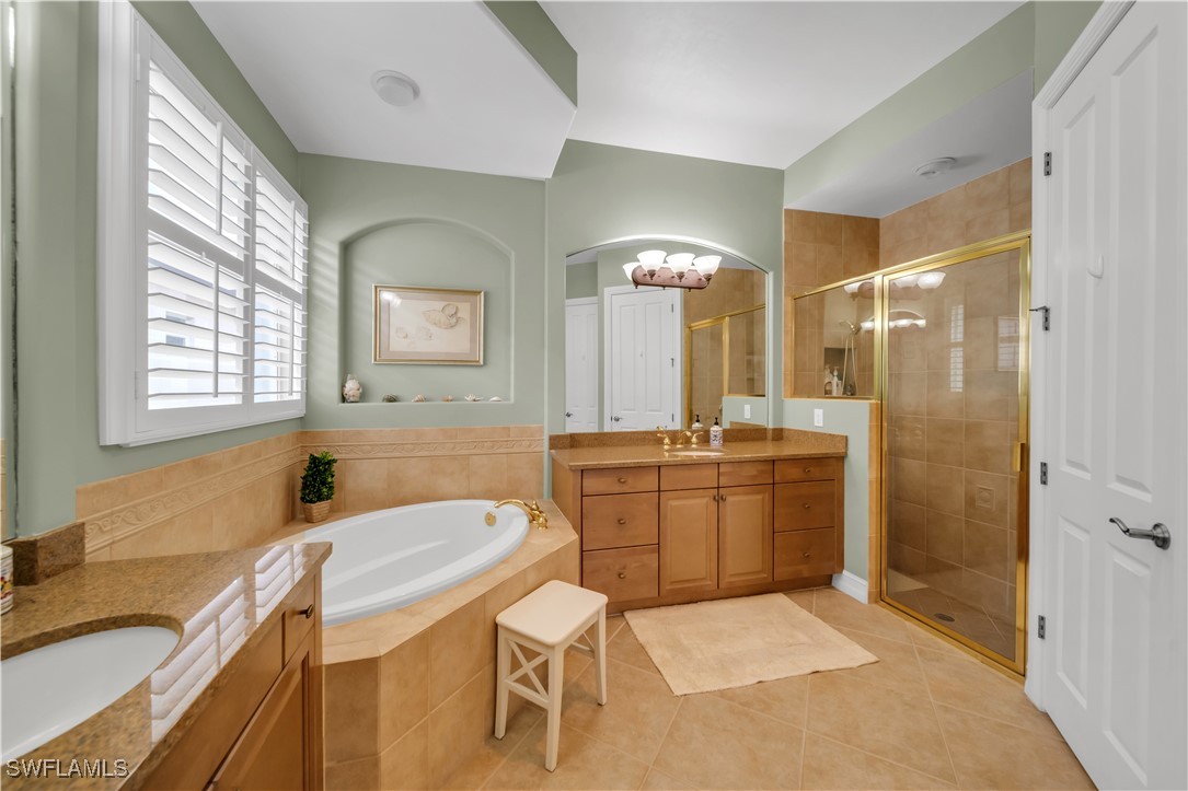 7672 Sussex Court Naples, FL 34113 - Photo 11 of 28 a bathroom with a granite countertop sink a toilet and shower