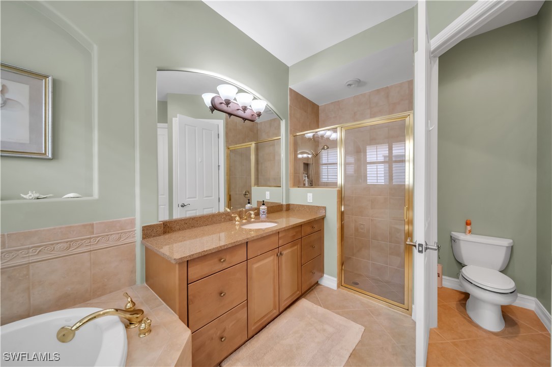 7672 Sussex Court Naples, FL 34113 - Photo 12 of 28 a spacious bathroom with a granite countertop sink a toilet and a shower
