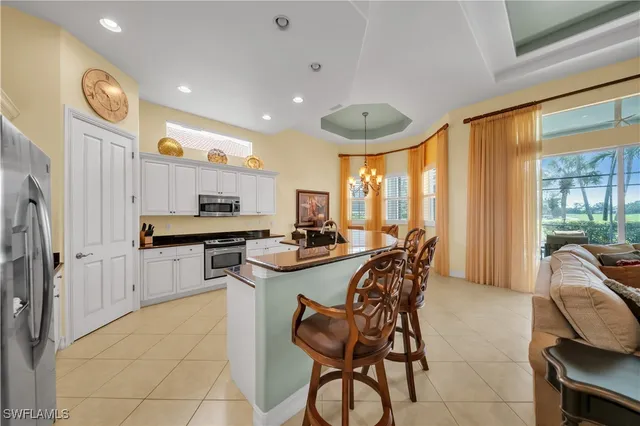 a kitchen with stainless steel appliances a table and chairs in it