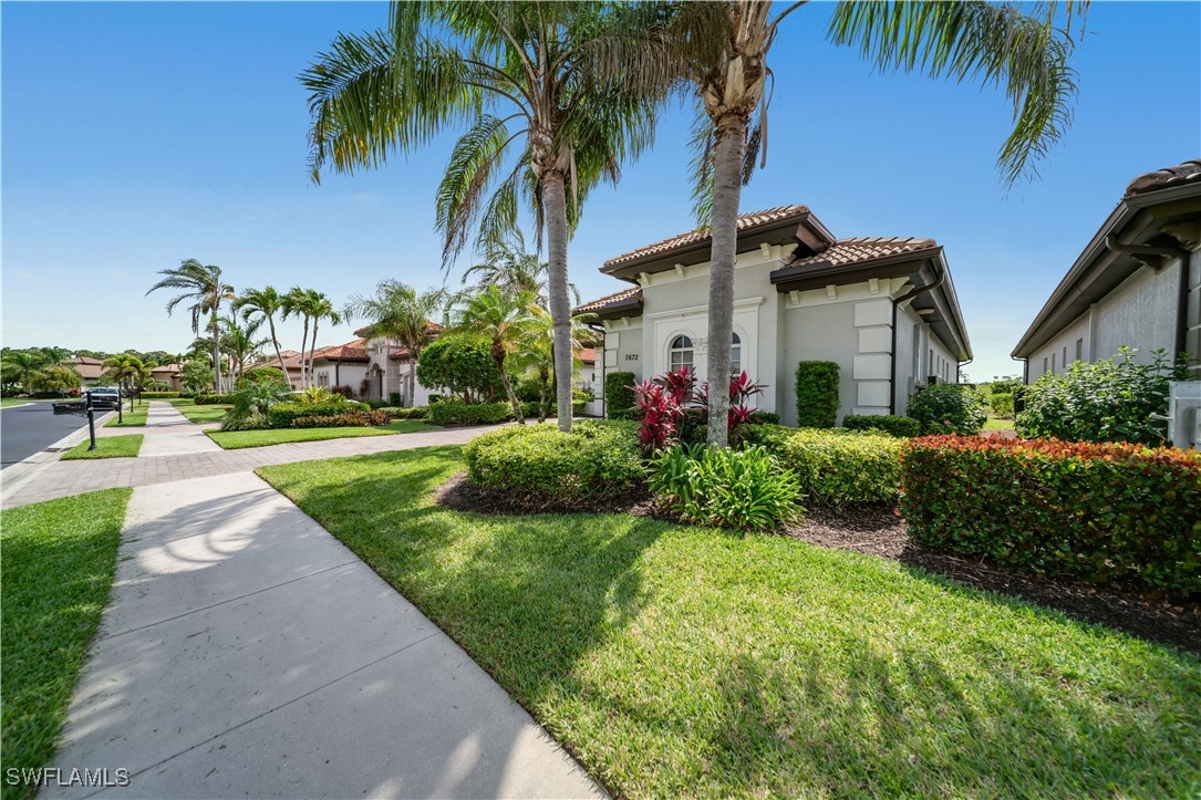 7672 Sussex Court Naples, FL 34113 - Photo 23 of 28 a front view of a house with a garden