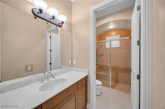 a bathroom with a granite countertop sink a toilet and shower