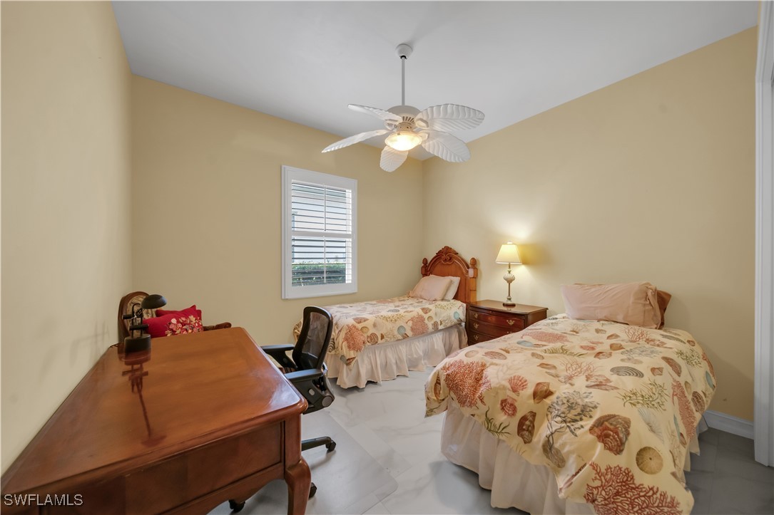 7672 Sussex Court Naples, FL 34113 - Photo 6 of 28 a bedroom with two beds and a chandelier
