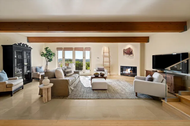 a bedroom with furniture and a large window