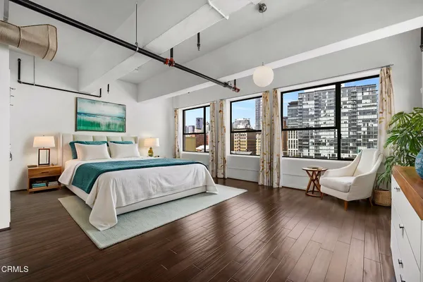 a bedroom with a large bed and wooden floor